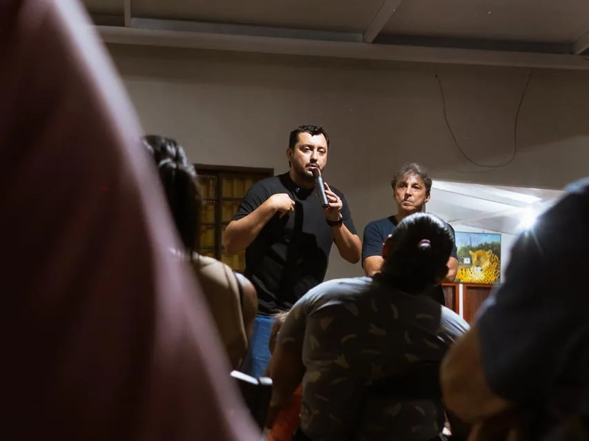 Allan Kardec fala ao microfone em reunião com moradores